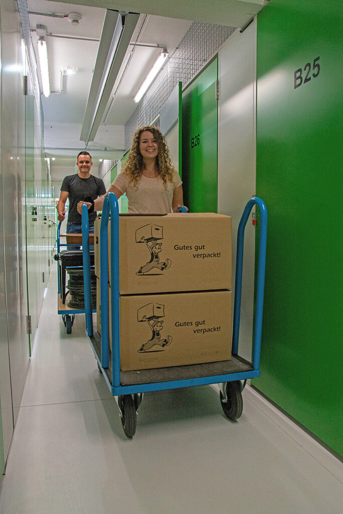 Transport von Umzugskartons durch die Lagergänge der Packsweg Lagerboxen